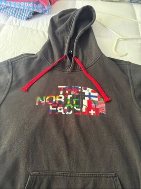 The North Face Black Hoodie with Red Drawstrings and Multi-Flag Logo